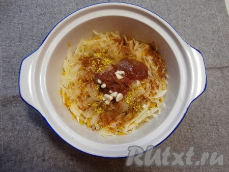 Влить воду, накрыть кастрюльку крышкой и отправить в микроволновую печь на 8 минут при мощности СВЧ 750 Ватт. Затем добавить в капусту томатную пасту и кетчуп, чёрный молотый перец, нарезанный чеснок, соль, паприку и приправу для овощей.