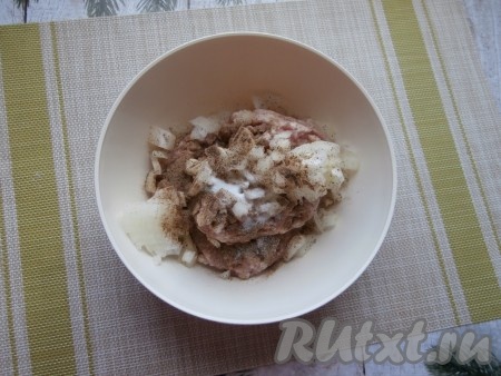 Луковицу очистить, мелко нарезать (или пропустить через мясорубку), а затем переложить к фаршу, всыпать соль и молотый чёрный перец.
