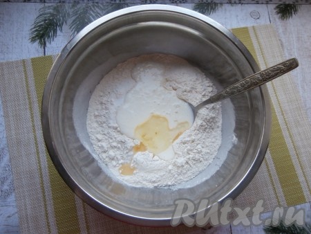 Прежде всего нужно просеять в глубокую миску 2 стакана муки, добавить сахар, соль, сделать в центре углубление. В это углубление влить растительное масло и 100 миллилитров кефира комнатной температуры (я подогрела кефир до комнатной температуры в течение 20 секунд в микроволновке).