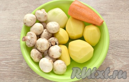 Очищаем картофель, морковку и лук, ополаскиваем. Шампиньоны тоже промываем водой, удаляя загрязнения на грибах. Картошины залейте водой, чтобы они не потемнели, пока мы будем обжаривать другие овощи и грибы.