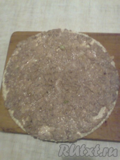 На смазанный корж выложить половину консервированной рыбы с луком.