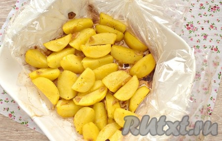 Форму с картофелем в рукаве ставим в разогретую до 200 градусов духовку на 30-40 минут. Спустя это время очень аккуратно, чтобы не обжечься, разрезаем пакет и отправляем картошку в духовку ещё на 10 минут. За это время картофельные дольки подрумянятся.