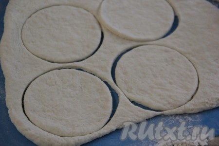Сначала перемешать тесто ложкой, а затем вымесить тесто руками. Тесто получится очень пластичным и удобным в работе. Готовое тесто на припылённой мукой поверхности раскатать скалкой в пласт толщиной, примерно, 0,5 см. Вырезать (например, с помощью стакана) кружочки любого размера. Я сделала кружочки диаметром 12 см. Оставшееся после вырезки кружочков тесто снова раскатать и тоже вырезать кружки. 
