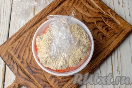 Соберите края плёнки к центру пиалы. Уберите салат из красной рыбы с творожным сыром и огурцом в холодильник минимум на 2 часа.