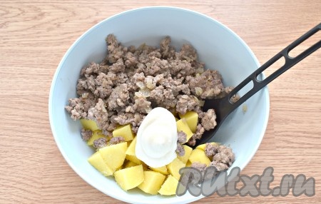 К картошке добавляем обжаренный фарш с луком, перчим. Выкладываем майонез к ингредиентам, перемешиваем, ещё немного солим.