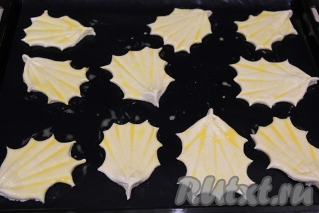 Яичный желток слегка взбить и смазать им верх заготовок.