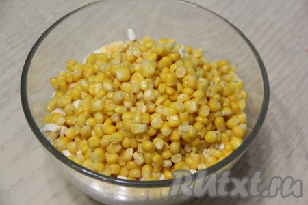 В миску с рисом, яйцам и крабовыми палочками выложить кукурузу без жидкости, добавить майонез, посолить по вкусу и перемешать.