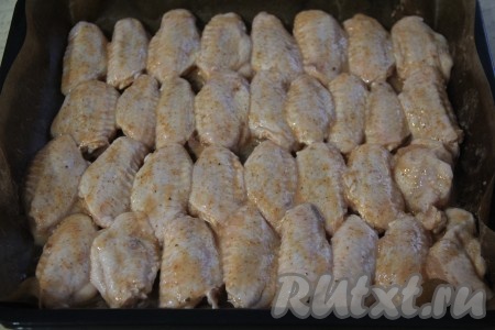 Противень застелить тефлоновым ковриком (или фольгой) и выложить куриные крылышки. Поставить противень с крыльями в разогретую духовку и запекать при температуре 200 градусов, примерно, 45-50 минут. 