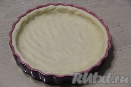 Большую часть теста выложить в форму (у меня керамическая форма диаметром 27 см). По желанию, форму, перед выкладыванием теста, можно немного смазать маслом. Равномерно распределить тесто по дну формы и сформировать невысокий бортик. Поставить форму с основой будущего пирога в холодильник на 30 минут.