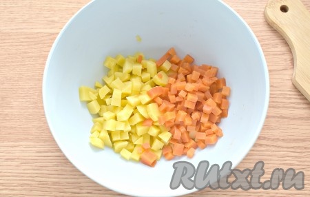 Заранее для салата отвариваем мякоть свинины (я с момента закипания воды варила мясо 1 час), бульон потом можно использовать для приготовления супа. Отваренное мясо полностью остудить. Отварить до готовности, не очищая от кожуры, морковь и картофель (я варила с момента закипания воды 25 минут). Не забудьте ещё и про яйца, их тоже следует заранее сварить вкрутую (на варку после закипания воды потребуется минут 10). Рекомендую после варки овощи и яйца поставить под холодную воду, так они и быстрее остынут, и будут лучше очищаться. Морковь, картошку, яйца остудить и очистить. Порядок нарезки ингредиентов роли не играет, главное, чтобы нарезанные ингредиенты были, примерно, одинакового размера. Картошку с морковкой нарезаем на мелкие кубики, сразу выкладываем в глубокую миску.