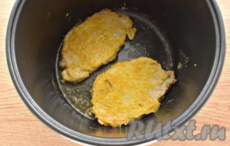 Отбивные из свинины перекладываем в уже разогретую с маслом чашу мультиварки, обжариваем с каждой стороны по 3-5 минут, не накрывая мультиварку крышкой. У меня на дне чаши поместились две отбивные.