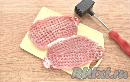 Каждый ломтик свинины отбиваем специальным кулинарным молоточком с двух сторон. Чтобы во время этого процесса брызги с мясных кусочков не разлетались в стороны, накройте ломтики пищевой плёнкой (или прозрачным целлофановым пакетом). Солим отбитые кусочки свинины.