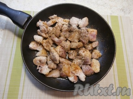 На сковороде прогреть растительное масло, затем выложить кусочки свинины и обжарить мясо на среднем огне до лёгкой румяности со всех сторон, периодически перемешивая. В процессе обжаривания мясо посыпать специями, хмели-сунели и чёрным молотым перцем.