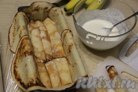 Плотно выложить рулетики из блинов с бананами в форму. Если рулетик не влезает целиком, то его можно подрезать по длине формы.