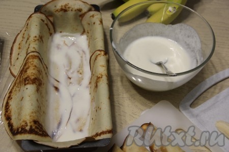 Смазать дно формы с блинами сметанным кремом.