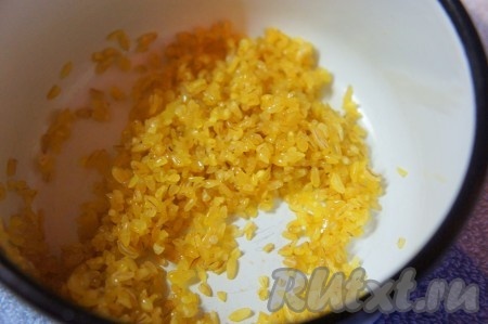 Добавить булгур в растопленное масло, тщательно и быстро перемешать.