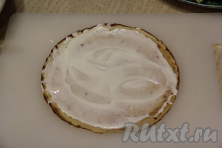 Теперь можно приступать к формированию блинного торта. Взять один остывший блин, смазать его кремом из сметаны и сгущёнки. 