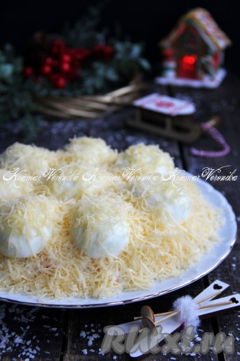 Присыпать половинки яиц натёртым сыром. Дать аппетитному, вкусному, нежнейшему салату "Снежные сугробы" пропитаться пару часов, а затем подать к новогоднему столу. 