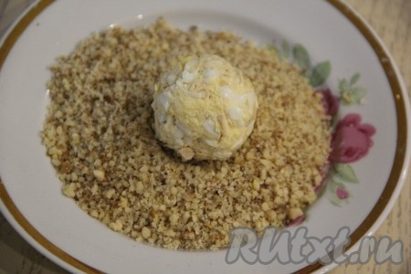 Сформировать из массы шарики любого размера. Я сделала шарики размером чуть крупнее грецкого ореха (у меня получилось 20 шариков). В отдельную тарелку выложить грецкие орехи, измельчённые в мелкую крошку. Обвалять шарики в ореховой крошке со всех сторон.