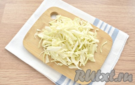 Ставим на сильный огонь кастрюлю с 1,5 литрами воды. Как только вода закипит, выкладываем в неё тонко нарезанную капусту, даём закипеть и убавляем огонь до среднего.