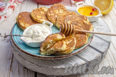 Вкусные, аппетитные оладьи, приготовленные из теста, замешанного из творога и кефира, подавайте с пылу с жару, дополнив сметаной, мёдом, вареньем или сгущёнкой.