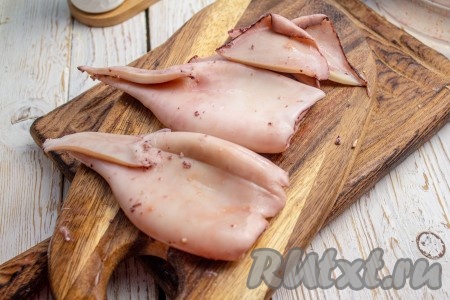 Очистите кальмаров от плёнки, покрывающей их поверхность, и вытащите хитиновую пластинку, расположенную внутри каждой тушки, тщательно промойте внутри и снаружи.