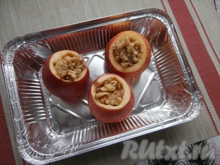 Наполнить углубления яблок орехово-медовой смесью. Поместить яблоки с начинкой в любую, подходящую для запекания форму.