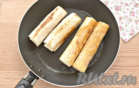 В сковороде разогреваем растительное масло. Помещаем на сковороду сосиски с сыром в лаваше и обжариваем их с каждой стороны до румяной корочки (примерно, по 1,5-2 минуты) с каждой стороны на среднем огне.