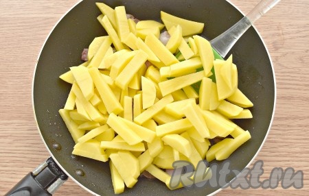 Добавляем нарезанную картошку, перемешиваем. Прибавляем нагрев плиты и жарим, примерно, 10 минут картошку. Часто перемешивать картофель с беконом не нужно, достаточно 2-3 раза за 10 минут.