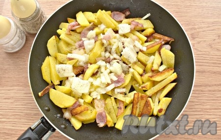 Затем к картошке добавляем очищенный и произвольно нарезанный лук, по вкусу солим и перчим. Продолжаем жарить ещё 5-6 минут, иногда перемешивая.