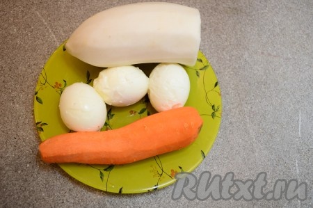 Подготовить продукты для приготовления салата из дайкона с яйцами и морковью.  Заранее отварить 3 яйца вкрутую (то есть отвариваем яйца после начала кипения воды минут 8-10), затем остудить их полностью и очистить от скорлупы. Дайкон и морковь очистить.