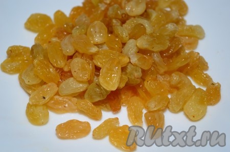 Изюм заранее отмерить, выложить в глубокую чашку и залить кипятком. Через 3-5 минут воду слить, а изюм обсушить. Удобно обсушивать изюм на чистом кухонном полотенце (или на бумажных полотенцах, или на белых салфетках без рисунка).