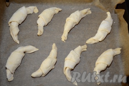 Таким же образом формируем оставшиеся круассаны. Противень застилаем пекарской бумагой. Если не уверены в качестве бумаги, то дополнительно смажьте её поверхность растительным маслом. У меня проверенная бумага с силиконовой пропиткой, поэтому я её не смазывала. Выкладываем круассаны с сыром на противень, застеленный бумагой, на расстоянии друг от друга.