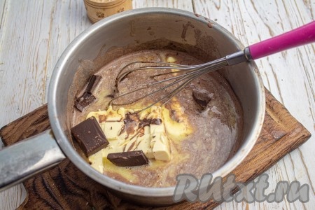 В горячее молоко с какао добавьте нарезанное на кусочки сливочное масло и кусочки чёрного шоколада. Активно перемешайте до полного растворения масла и шоколада.