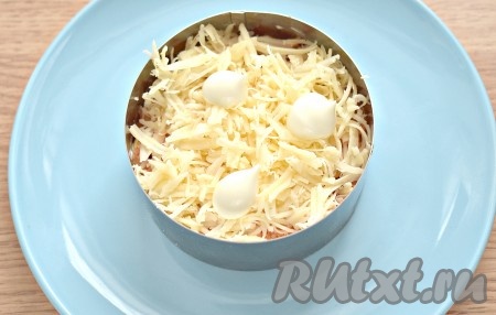 Поверх моркови выкладываем натёртый на средней тёрке сыр, тоже смазываем его майонезом.