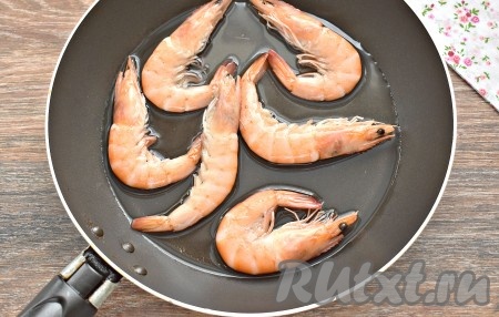 Креветки перекладываем в сковороду, вливаем тёплую прокипячённую воду и на сильном огне провариваем их в течение 2-3 минут после закипания, затем переворачиваем и продолжаем готовить ещё 2 минуты. Вода должна полностью испариться.