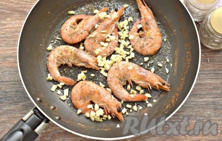 Сюда же добавляем нарезанный чеснок, по своему вкусу солим и перчим. Посыпаем креветки сушёными прованскими травами.