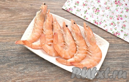 Я использовала замороженные королевские креветки в панцире. Их нужно заранее достать из морозилки, чтобы они разморозились при комнатной температуре. Размороженные креветки переложить в дуршлаг, обдать прохладной водой, оставить на несколько минут, чтобы с морепродуктов слилась лишняя вода. А затем промокнуть креветки бумажными полотенцами.
