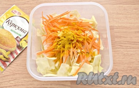 К капусте, чесноку и моркови всыпаем куркуму и сразу перемешиваем.

