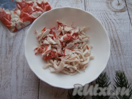 Нарезать кальмаров тонкой соломкой, крабовое мясо нарезать небольшими кусочками. Соединить крабовое мясо и кальмаров в глубокой миске.