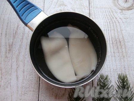 Если кальмары замороженные, разморозьте их при комнатной температуре. У меня были очищенные тушки кальмаров, мне их чистить не пришлось. Если у вас кальмары не очищенные, то их следует очистить от тёмной плёночки, покрывающей их поверхность, удалить хорду, находящуюся внутри тушек. Подготовленных кальмаров поместить в кастрюльку, залить холодной водой.