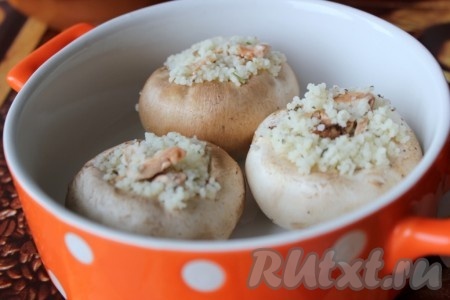 Начинку поместить в шляпки шампиньонов, уложить их в формы и запечь в духовке около 20 минут при 200 градусах.