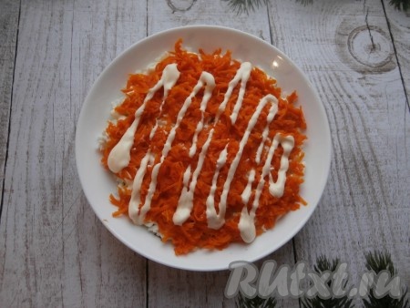 Одну морковку натереть на мелкой тёрке, равномерно выложить следующим слоем, слегка посолить и нанести майонез.
