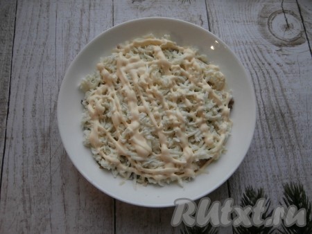 Яйца разделить на белки и желтки. На шпроты выложить слой натёртых белков, этот слой щедро смазать майонезом.