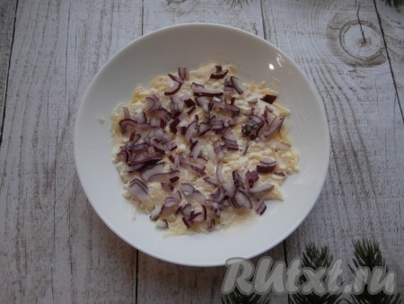 Очищенную половинку луковицы мелко нарезать, выложить на картофель.