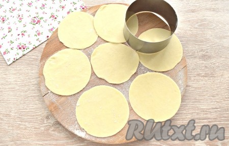 Тесто достаём из целлофана, делим на 3-4 куска. Каждый кусок теста на присыпанной мукой поверхности раскатываем в пласт толщиной около 2 мм. Сервировочным кольцом (или подходящей чашкой) вырезаем круглые заготовки для мини-чебуреков. Я использовала кольцо диаметром 8 см