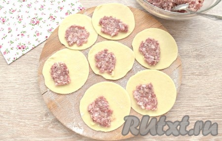 На одной стороне заготовки теста размещаем немного меньше чайной ложки фарша, стараясь его размазать тонким слоем.