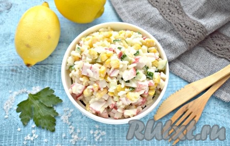 Вкусный, яркий салат с крабовым мясом и рисом готов, по желанию, украшаем его зеленью и подаём на стол.