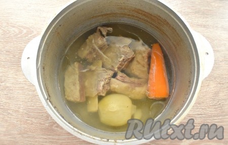 За время варки вода немного выкипит, при необходимости, можно добавить её из чайника. Лично мне нравится густая шурпа, поэтому воду я не добавляла. Из казана достаём рёбрышки, после остывания нарезаем их на средние кусочки. Варёные морковку и лук можно выбросить, они нам больше не потребуются.