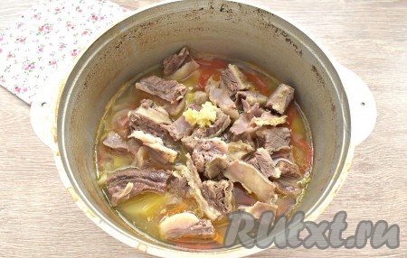 По истечении 10 минут, добавляем в суп нарезанное мясо, срезанное с говяжьих рёбрышек, и пропущенный через пресс чеснок, варим шурпу 5-7 минут.
